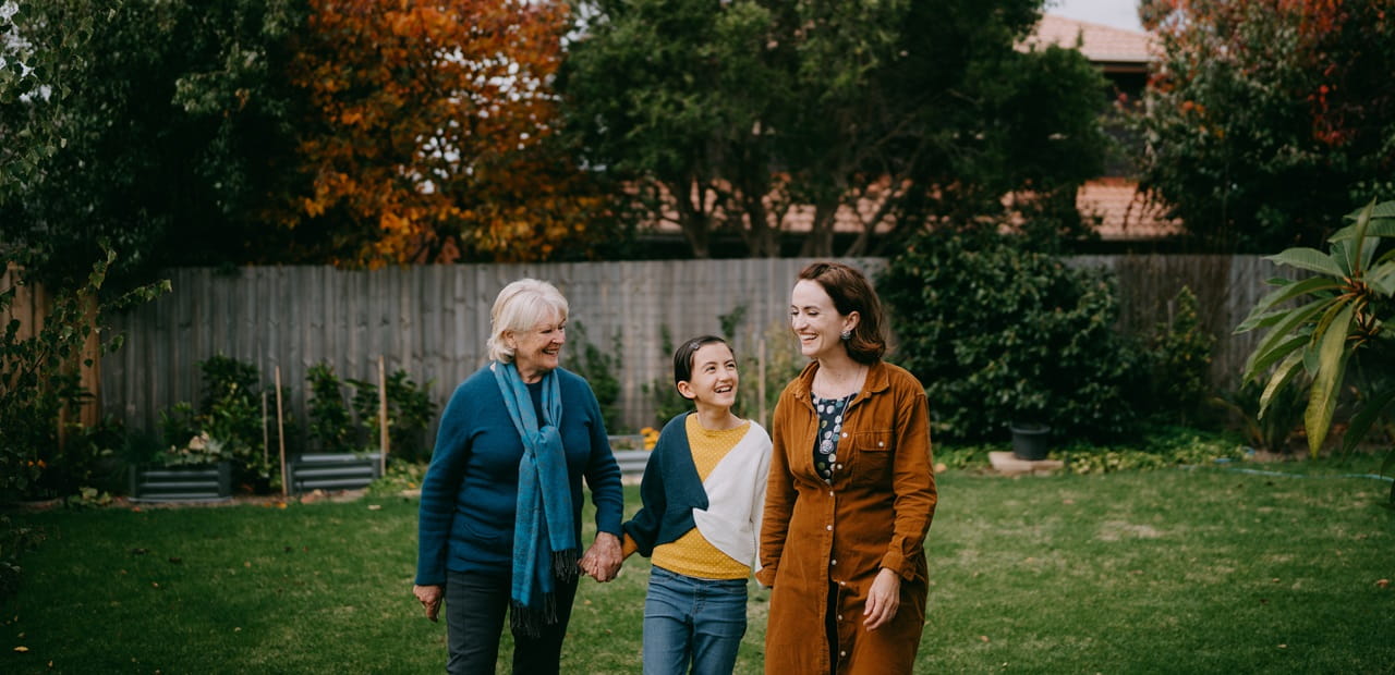 Young girl having fun with her grandmother and mother in backyard