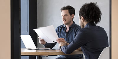 Men in office reviewing document