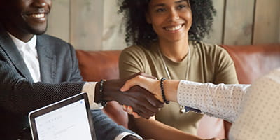 Happy african american couple making deal handshaking caucasian broker, closeup