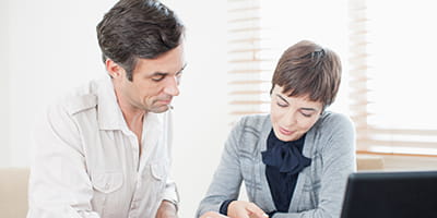 Businesswoman guiding man with paperwork