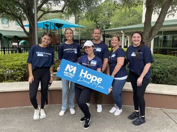 Associates wearing Raymond James Cares shirts hold 